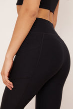 Load image into Gallery viewer, Female model wearing black pocket legging from wolven