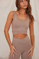 Woman wearing tan sports bra with matching yoga leggings