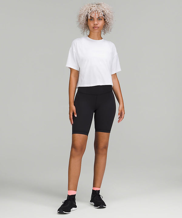 Woman wearing white t-shirt, black shorts, and black sneakers from lululemon