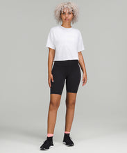 Load image into Gallery viewer, Woman wearing white t-shirt, black shorts, and black sneakers from lululemon