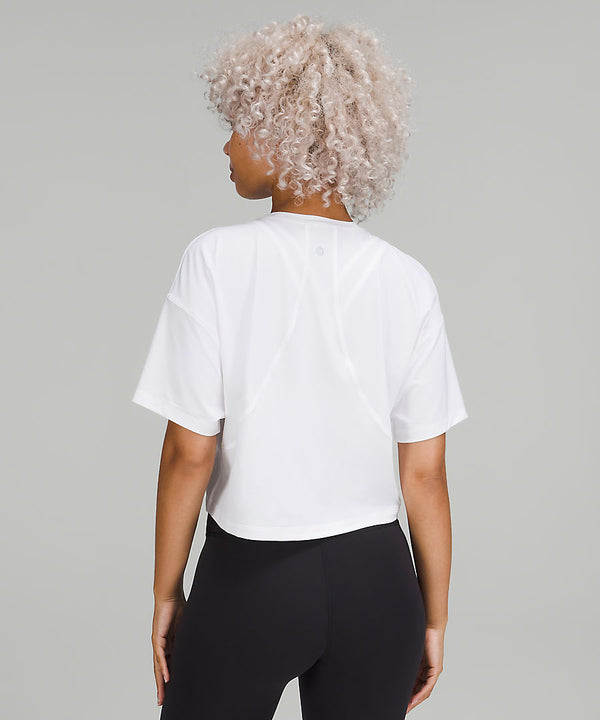 Back of a woman wearing a white t-shirt and black shorts from lululemon