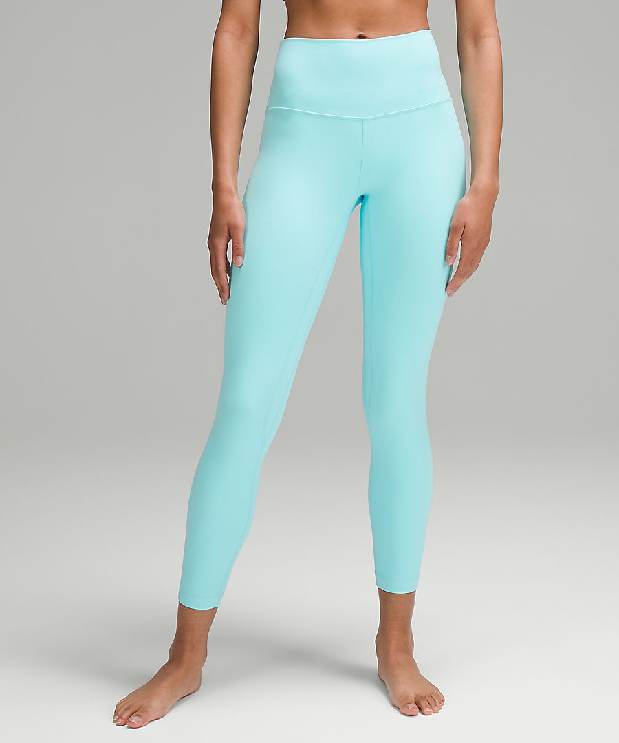 Legs of a woman wearing lululemon yoga leggings in cyan blue