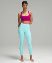 Load image into Gallery viewer, Woman wearing lululemon yoga leggings in cyan blue and a fuchsia sports bra