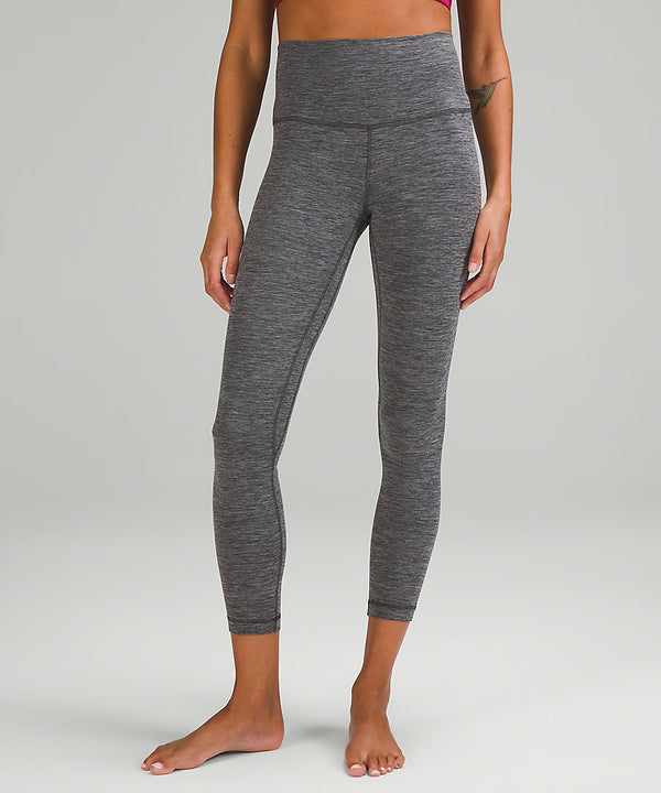 Legs of a woman wearing grey yoga leggings from lululemon