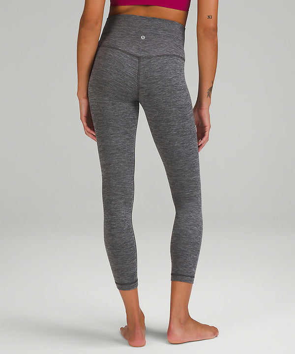 Back of a woman's legs, wearing grey yoga leggings from lululemon