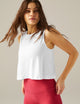 Woman wearing a white tank top and red pants