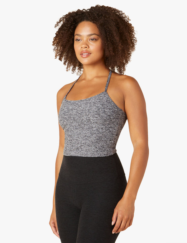 Woman wearing grey tank top and black yoga leggings from Beyond yoga. 