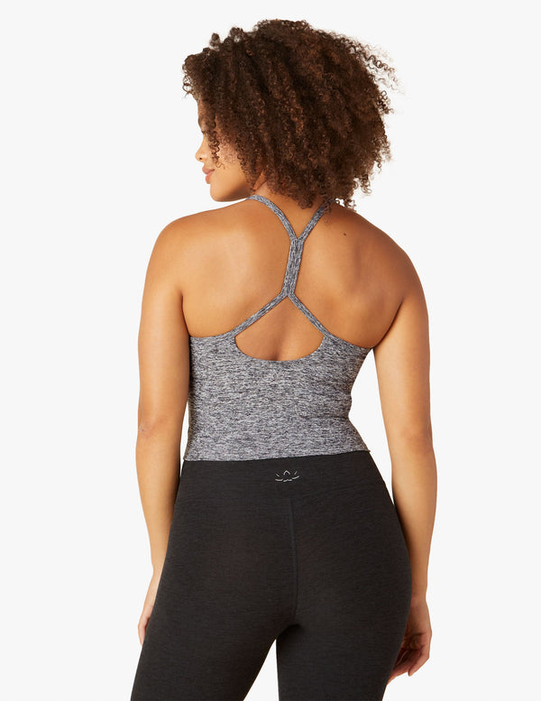 Woman wearing grey tank top and black yoga leggings from Beyond yoga. 