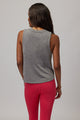 back of a woman wearing a grey tank top that reads "spiritual gangster"  and red pants