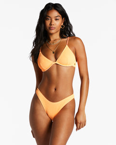 Woman wearing a tangerine bikini from Billabong.