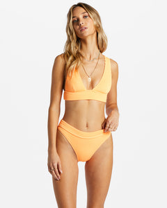 Woman wearing bikini in tangerine color from Billabong.