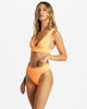 Woman wearing bikini in tangerine color from Billabong.