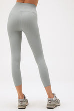 Load image into Gallery viewer, back of woman in stormy blue yoga leggings with grey sneakers