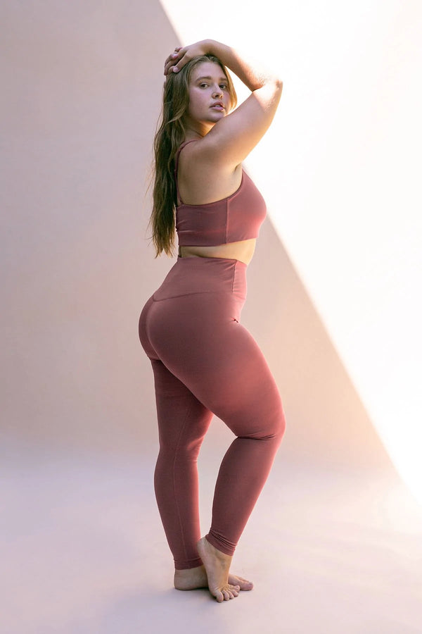 Female model wearing Fig colored leggings from Girlfriend Collective