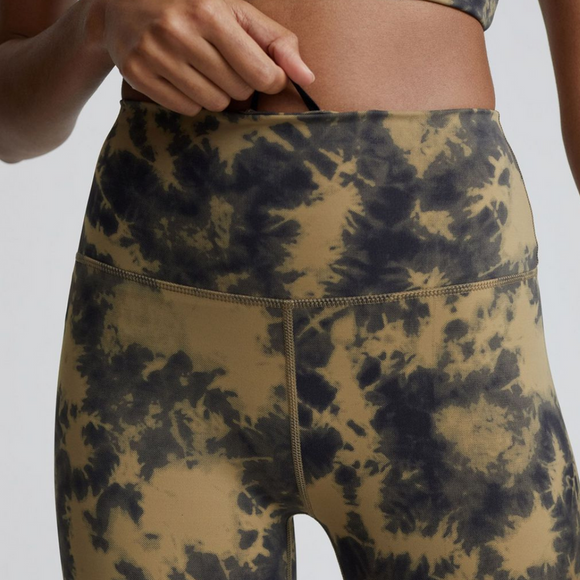 Female model wearing flaxen tie dye colored Let's Go High Rise leggings from Varley