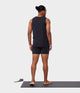 black male model standing on yoga mat wearing black tank and black athletic shorts