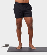 Load image into Gallery viewer, black male model standing on yoga mat wearing black athletic shorts