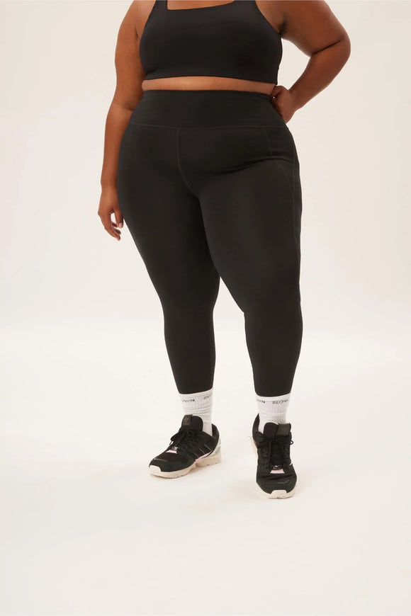 Female model wearing black leggings from Girlfriend Collective