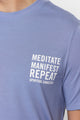 male model wearing "meditate, manifest, repeat" washed blue t-shirt from spiritual gangster 