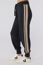 Load image into Gallery viewer, A young female model wearing gray striped Knit Joggers from Spiritual Gangster