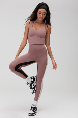 Female model wearing mauve colored leggings with matching crop top