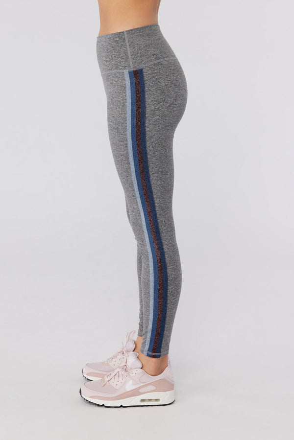 Female model wearing gray leggings with pink running shoes