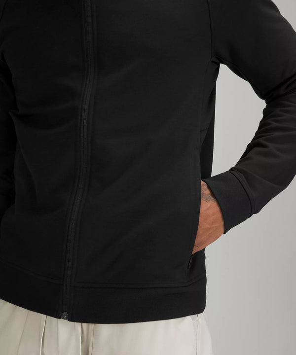 Male model wearing full zip black hoodie with hand in pocket
