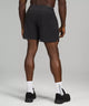 Black male model wearing black athletic shorts and black running shoes
