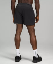 Load image into Gallery viewer, Black male model wearing black athletic shorts and black running shoes