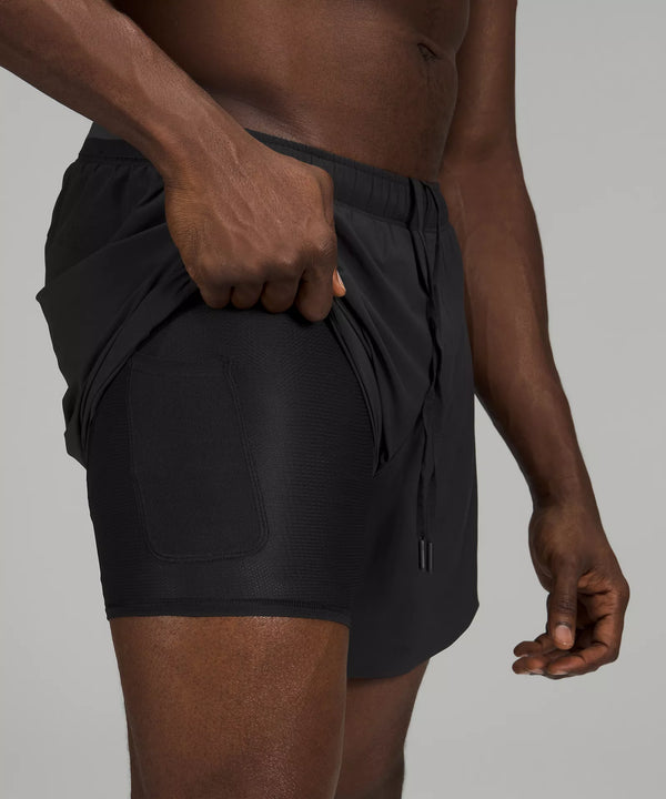 Black male model wearing black athletic shorts with compression underneath