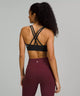 Female model wearing black sports bra and maroon leggings