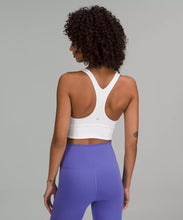 Load image into Gallery viewer, Black female model wearing white lululemon sports bra and purple leggings