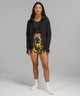 Female model wearing black full zip hoodie with colorful shorts and white running shoes