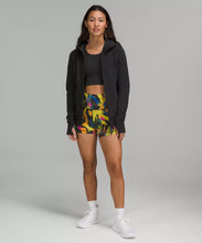 Load image into Gallery viewer, Female model wearing black full zip hoodie with colorful shorts and white running shoes