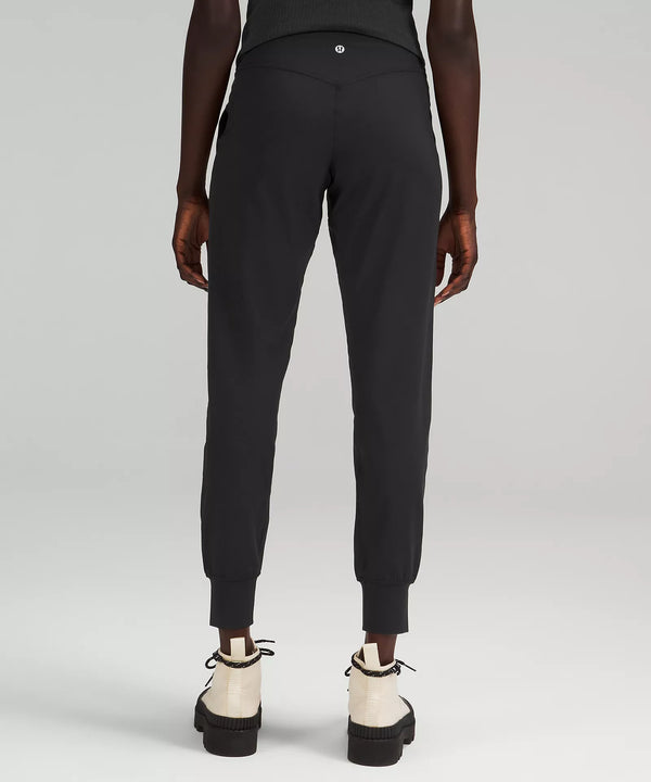 Female model wearing black joggers with cream boots