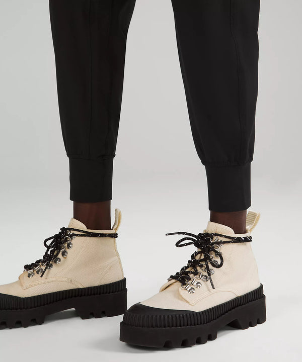 Female model wearing black joggers with cream boots