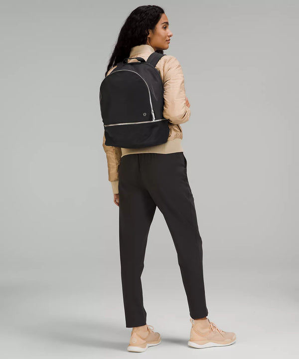 Model standing with black backpack on