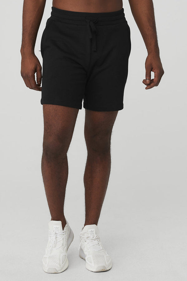 black male model wearing black athletic shorts and white running shoes