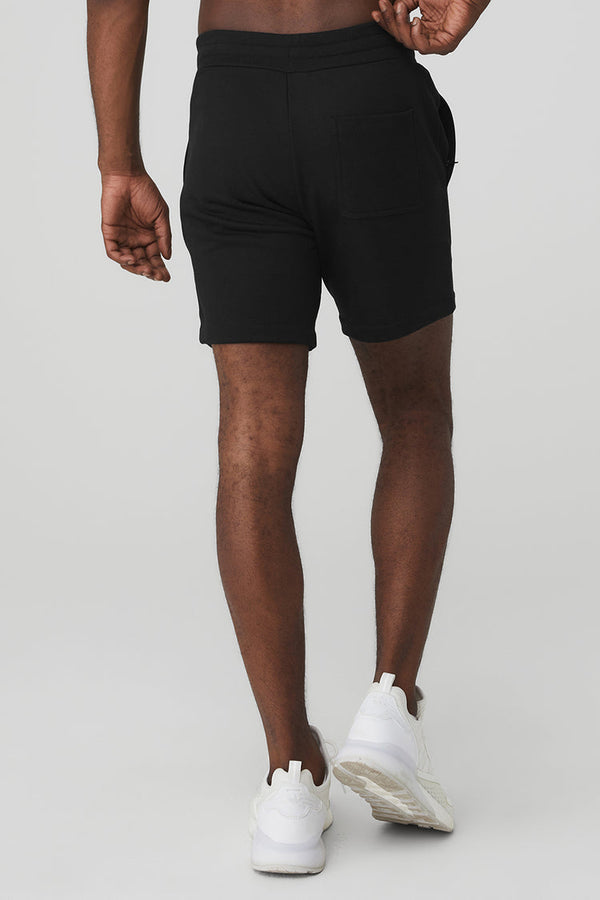 black male model wearing black athletic shorts and white running shoes