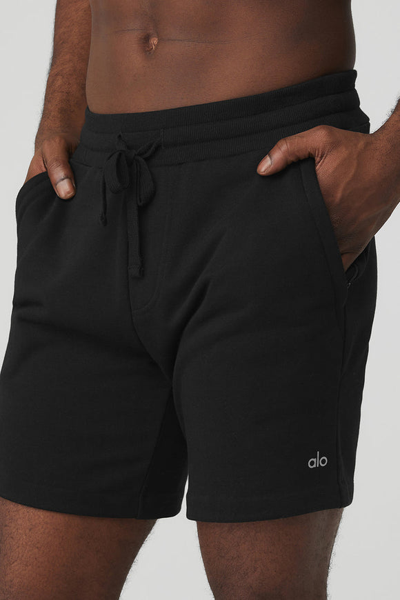 black male model wearing black athletic shorts with his hands in his pockets