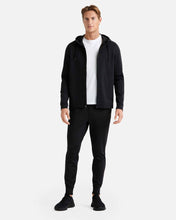 Load image into Gallery viewer, Male model wearing black athletic joggers with black zip up jacket and white t-shirt