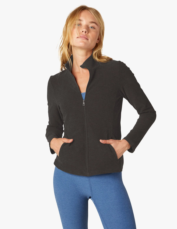 Female model wearing darkest night colored on the go mock neck jacket from beyond yoga