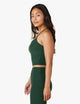 Female model wearing forest green pine tank from Beyond Yoga