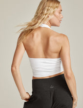 Load image into Gallery viewer, Back of woman wearing Woman wearing Beyond Yoga halter top in white and black beyond yoga pants. 
