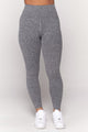 Model wearing grey leggings and white sneakers