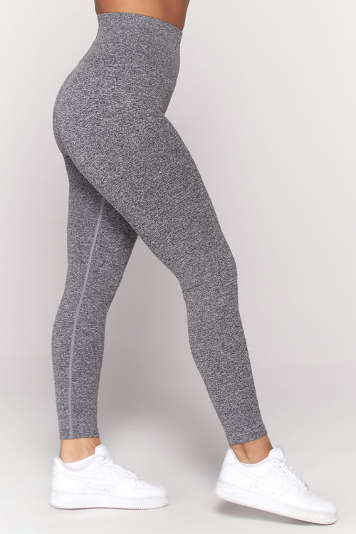 Model wearing grey leggings and white sneakers from the side