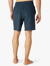 Load image into Gallery viewer, Back image of man wearing navy Beyond Yoga shorts