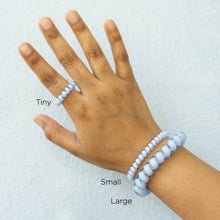 Load image into Gallery viewer, Hand with the three sizes of hair tie around wrist/finger to give scale for sizing