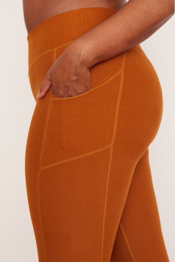 Female model wearing orange pocket legging from wolven