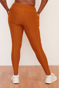 Female model wearing orange pocket legging from wolven